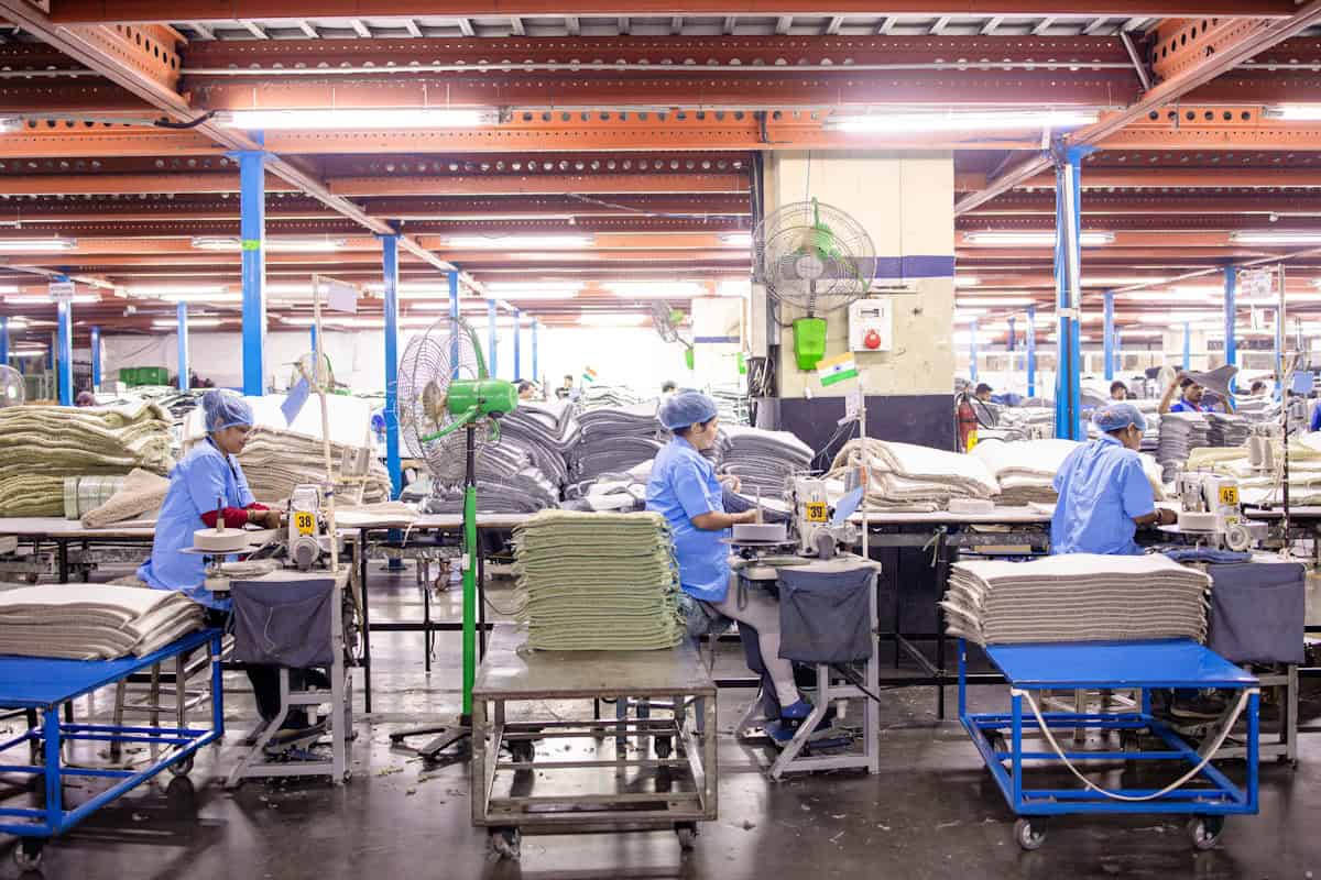 Trabalhadores em fábrica têxtil na China produzindo roupas para importação