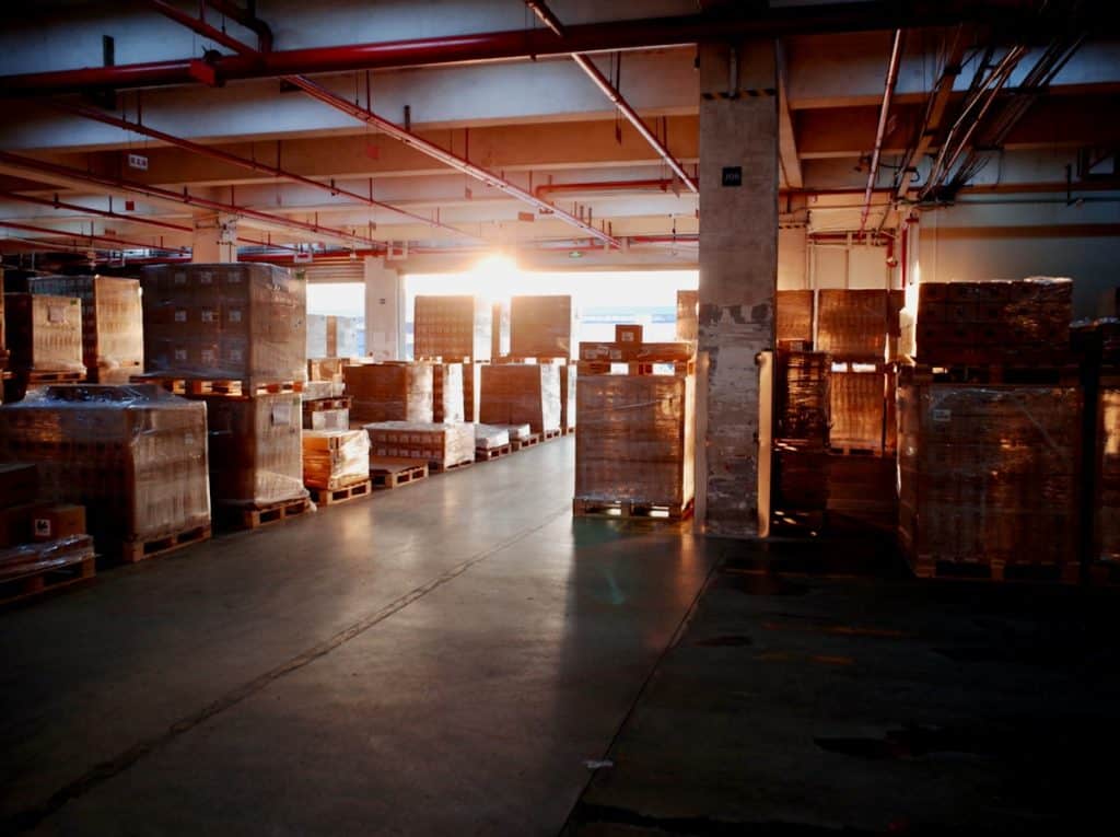 Armazém com paletes de mercadorias representando o entreposto aduaneiro e o regime RECOF