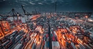 Contêineres empilhados em porto, simbolizando o processo de primeira importação para empresas