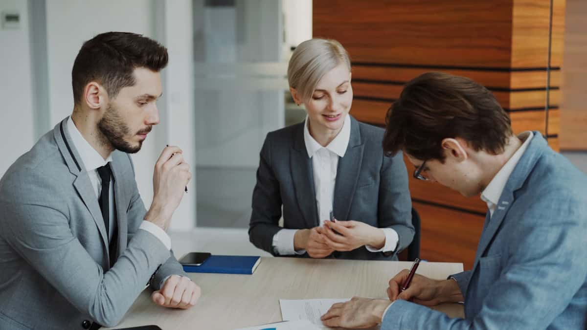 Pessoas assinando contrato representando a contratação do seguro-garantia aduaneiro